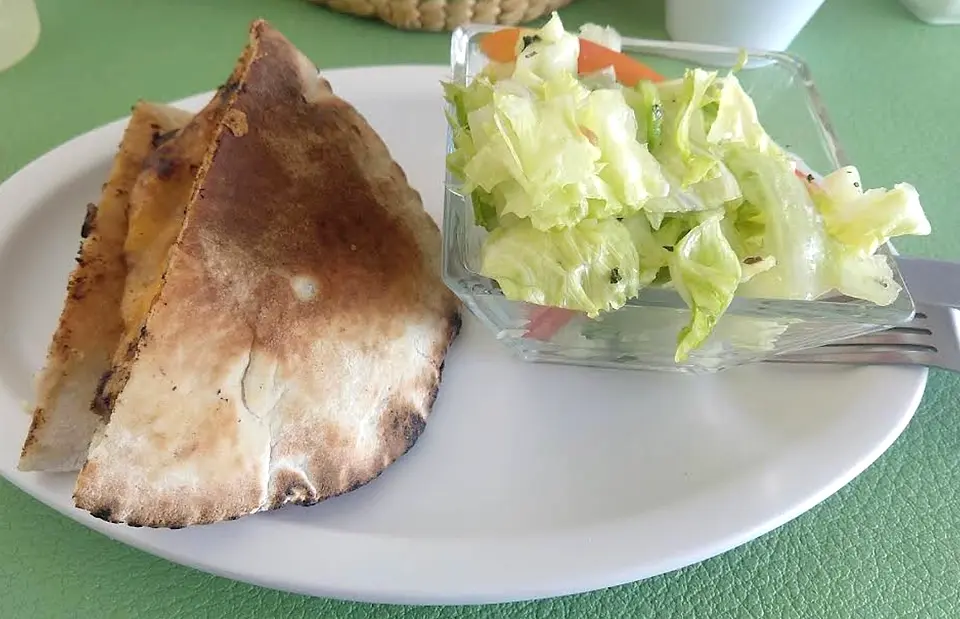 Camello tostado en mitades con ensalada árabe en un tazón de vidrio